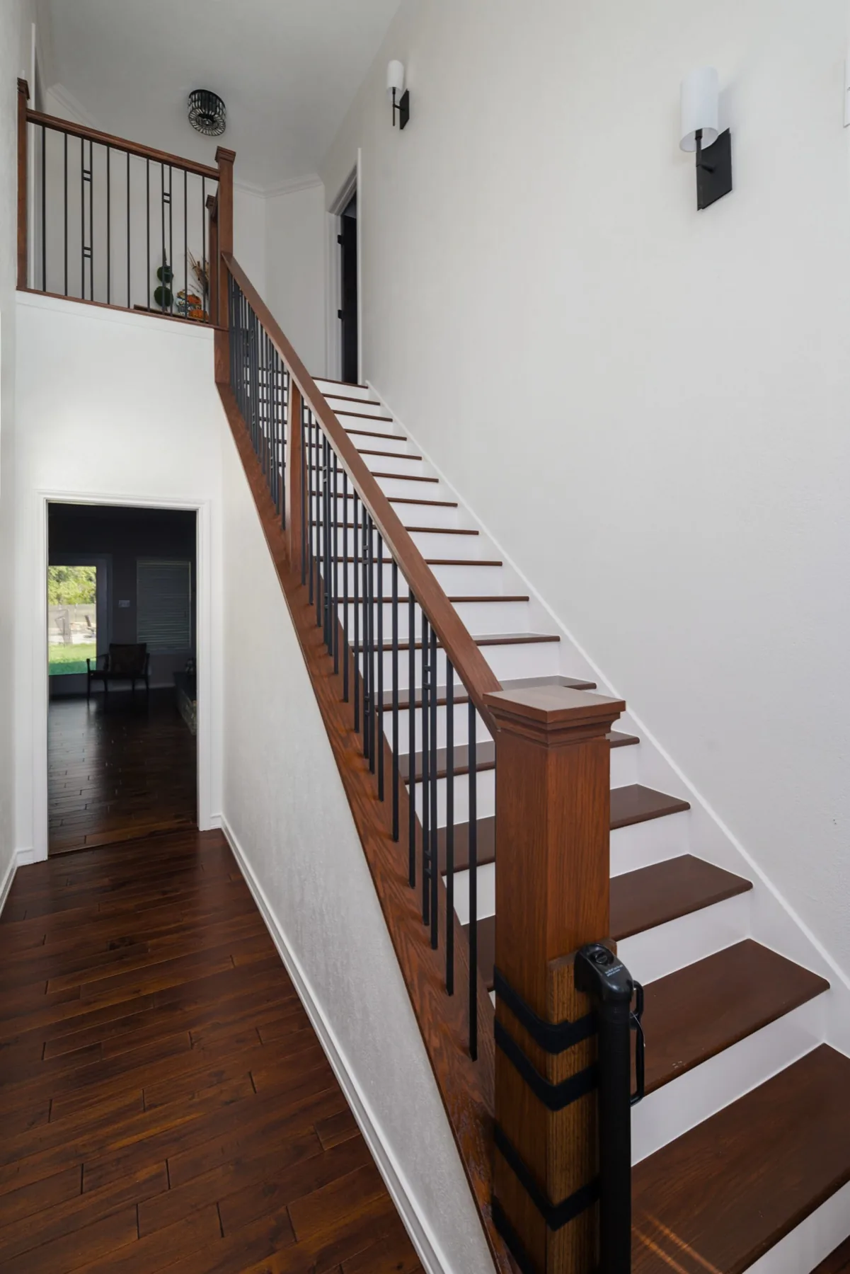 The modern farmhouse remodel staircase with oak rail and iron balusters