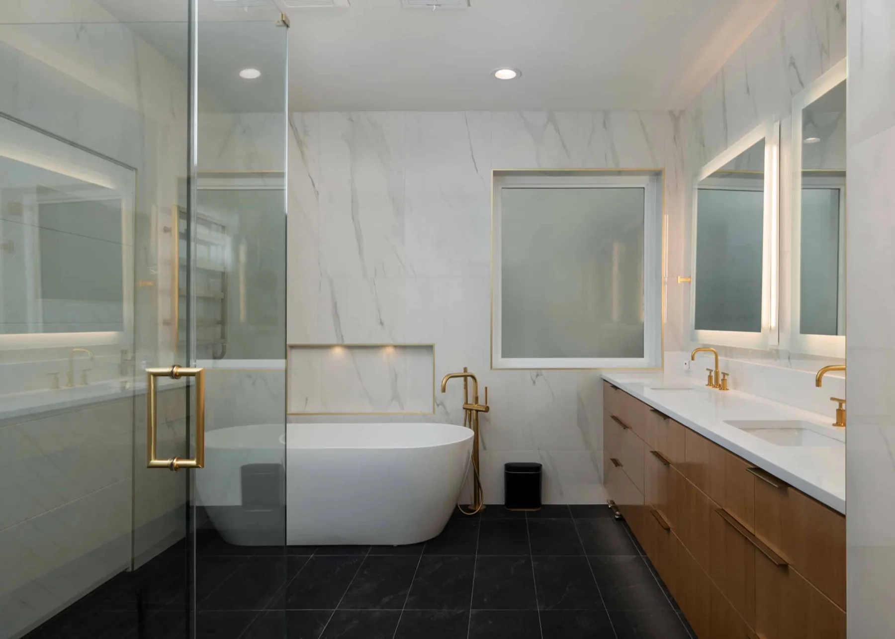 A master bath remodel with brass fixtures and a freestanding tub